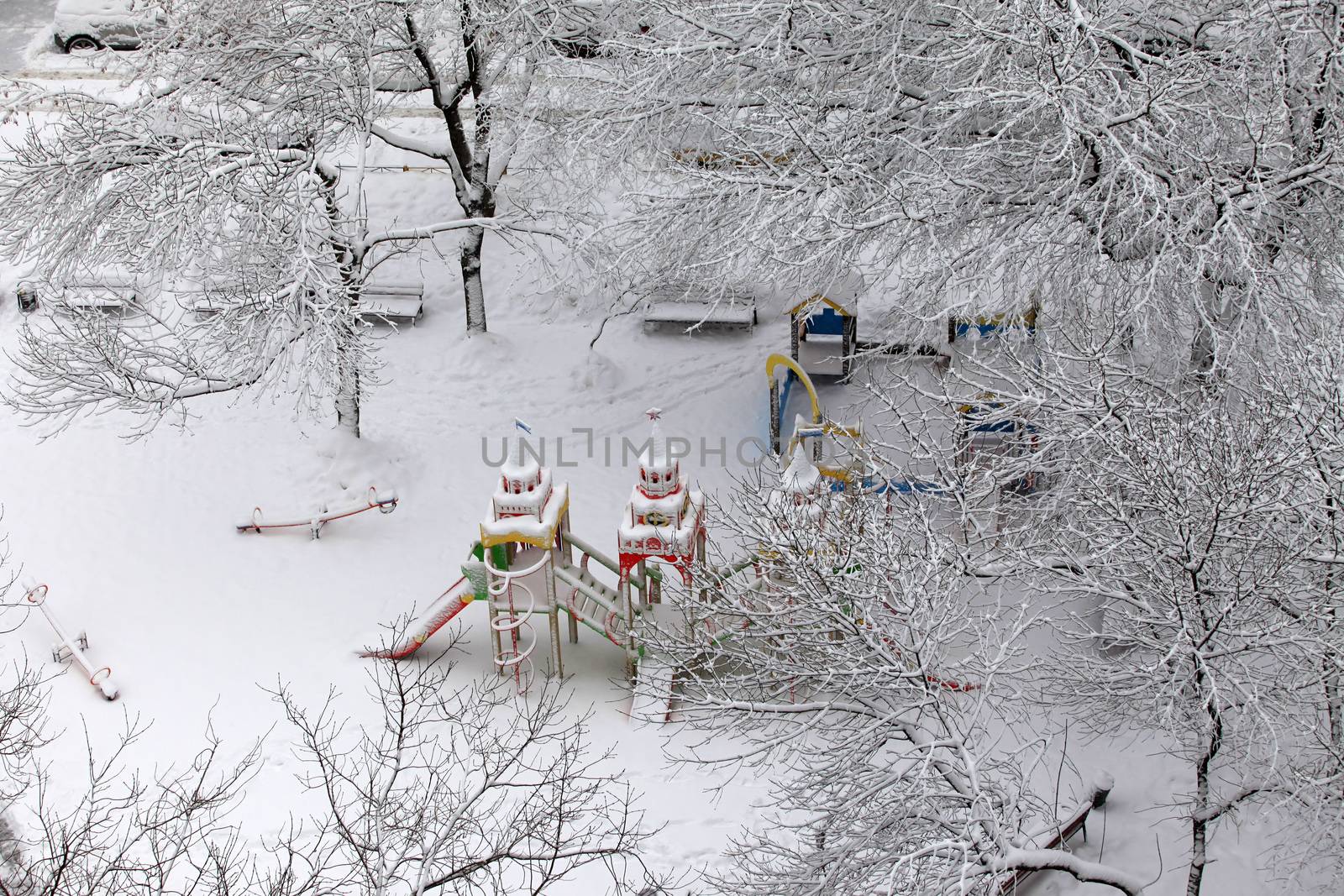 Deserted children's playground covered with snow