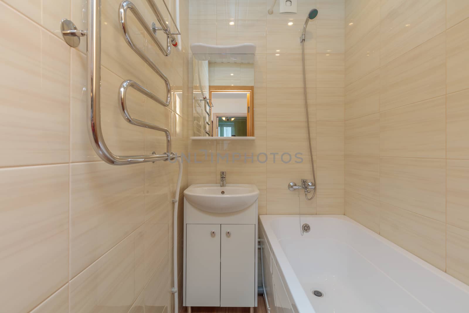 Small beige tile bathroom with bath tube and sink