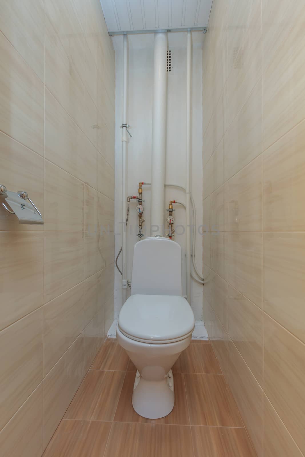 Toilet bowl in the toilet room. Restroom with brown tile decoration