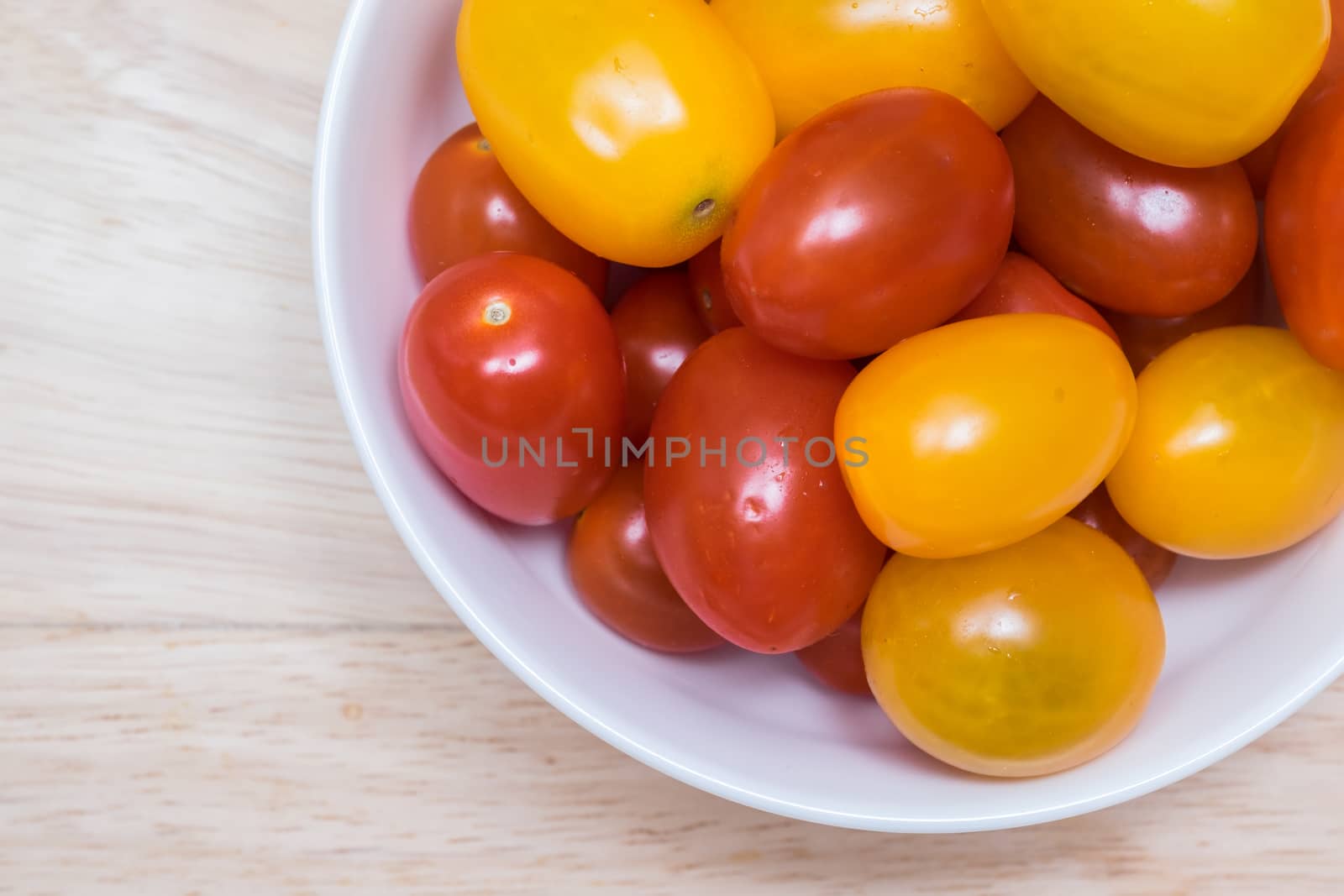 Red and yellow cherry tomatoes in a bowl.