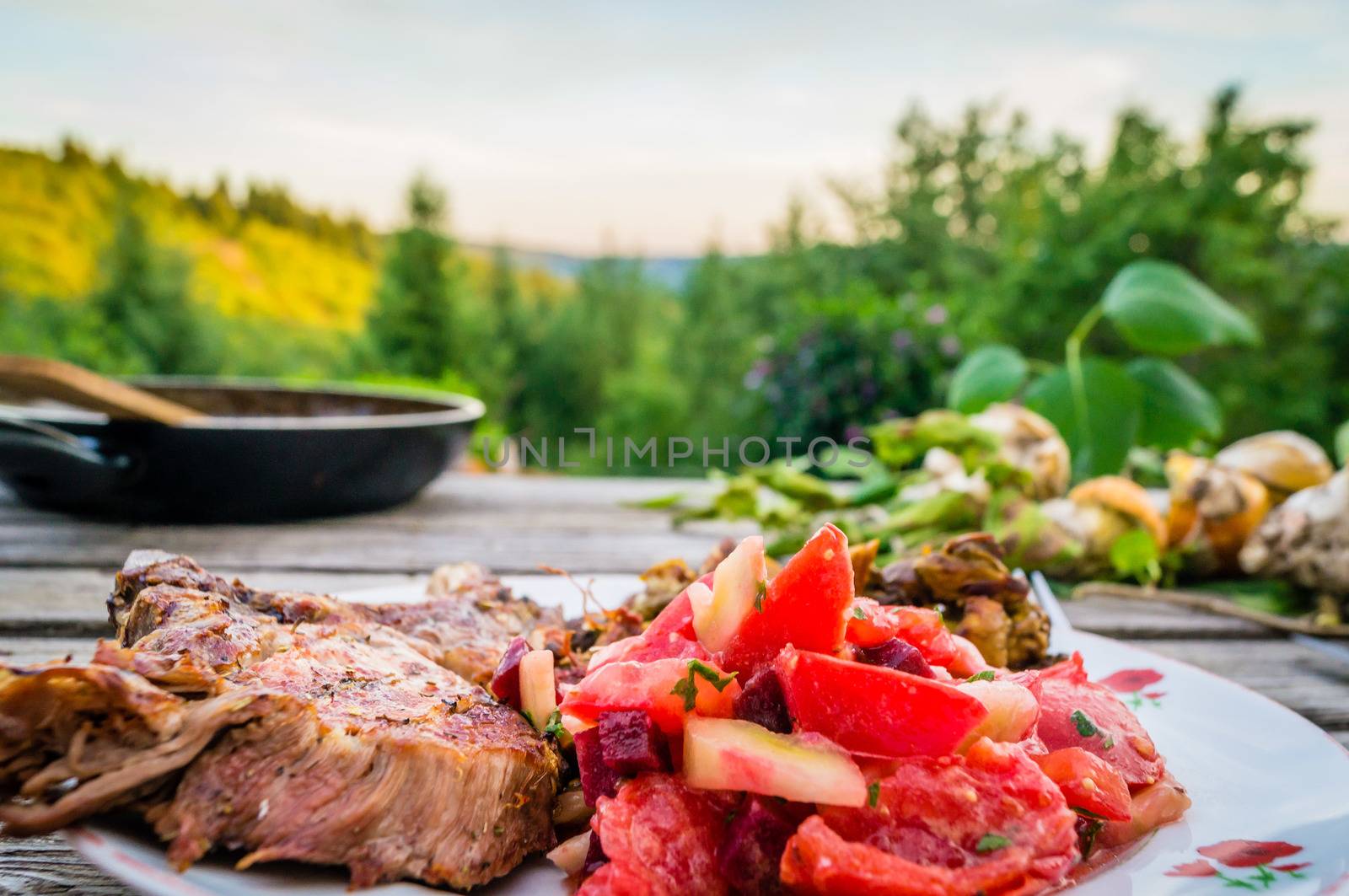 Nice meal of pork ribs and fresh tomatoes eaten outside in summer