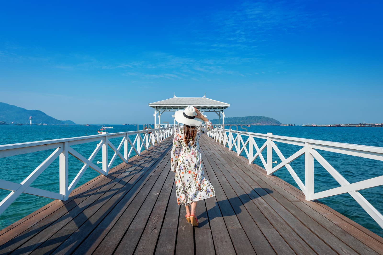 Young woman walking on wooden bridge in Si chang island, Thailan by gutarphotoghaphy