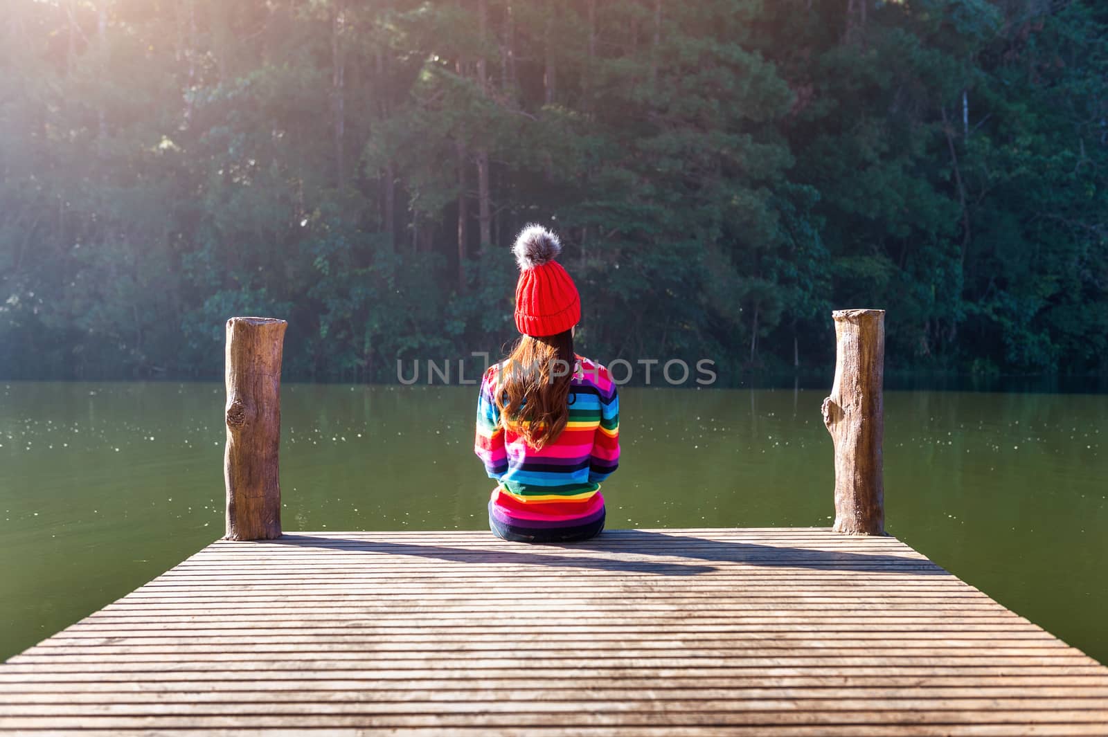 Young girl sitting on a pier. by gutarphotoghaphy