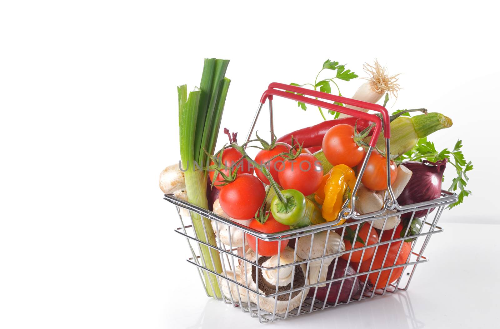 Raw vegetables in basket isolated on white