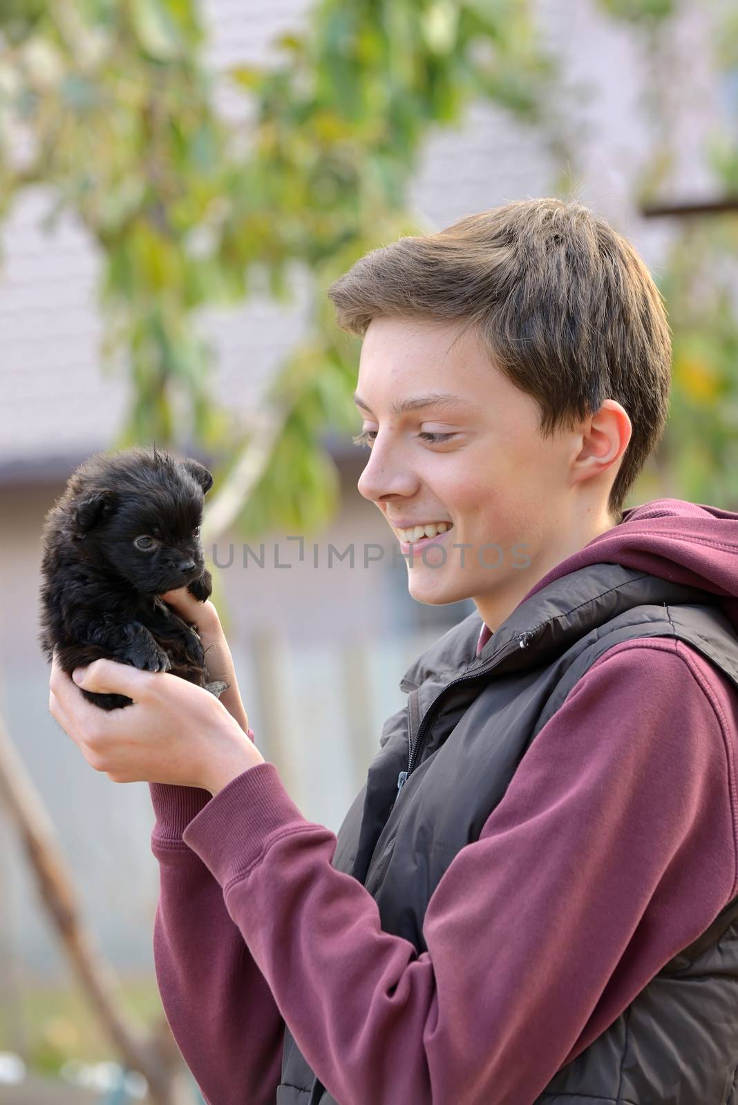 Teenager with a small puppy at farm