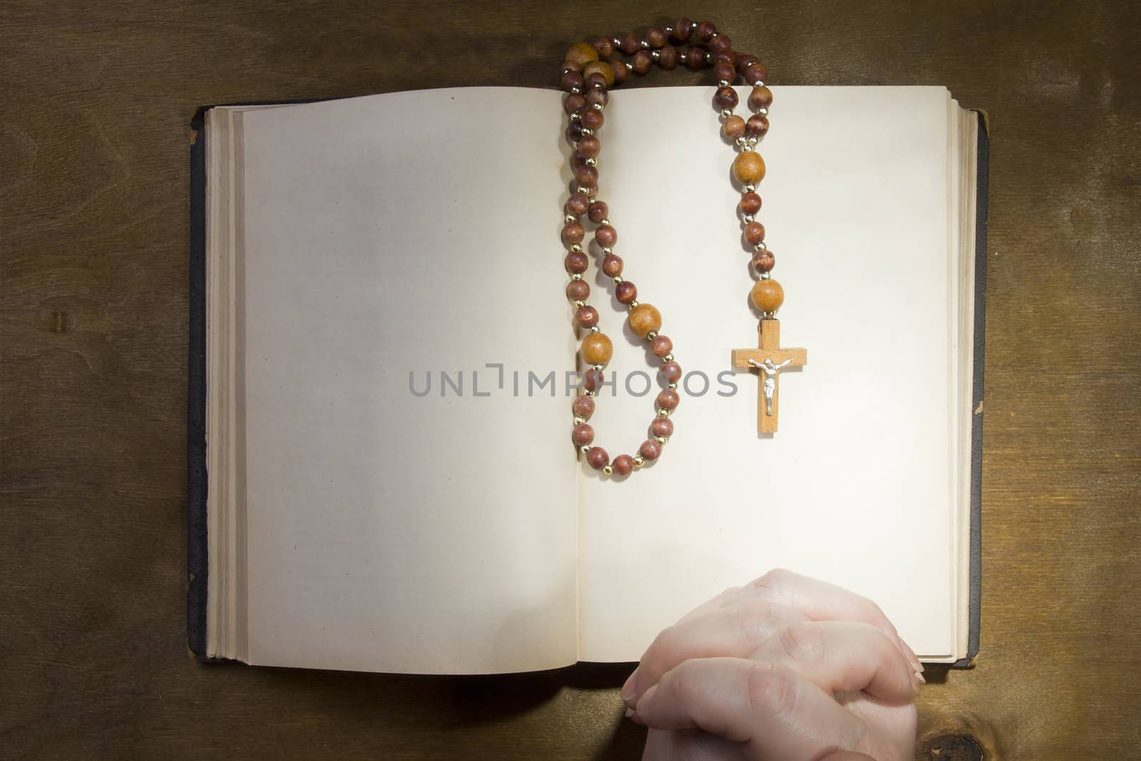 Hands with rosary and an old book by VIPDesignUSA