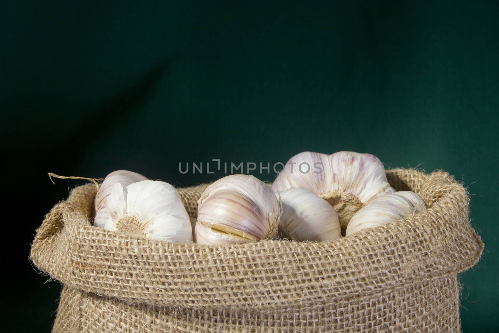 Garlic in a bag on a green background