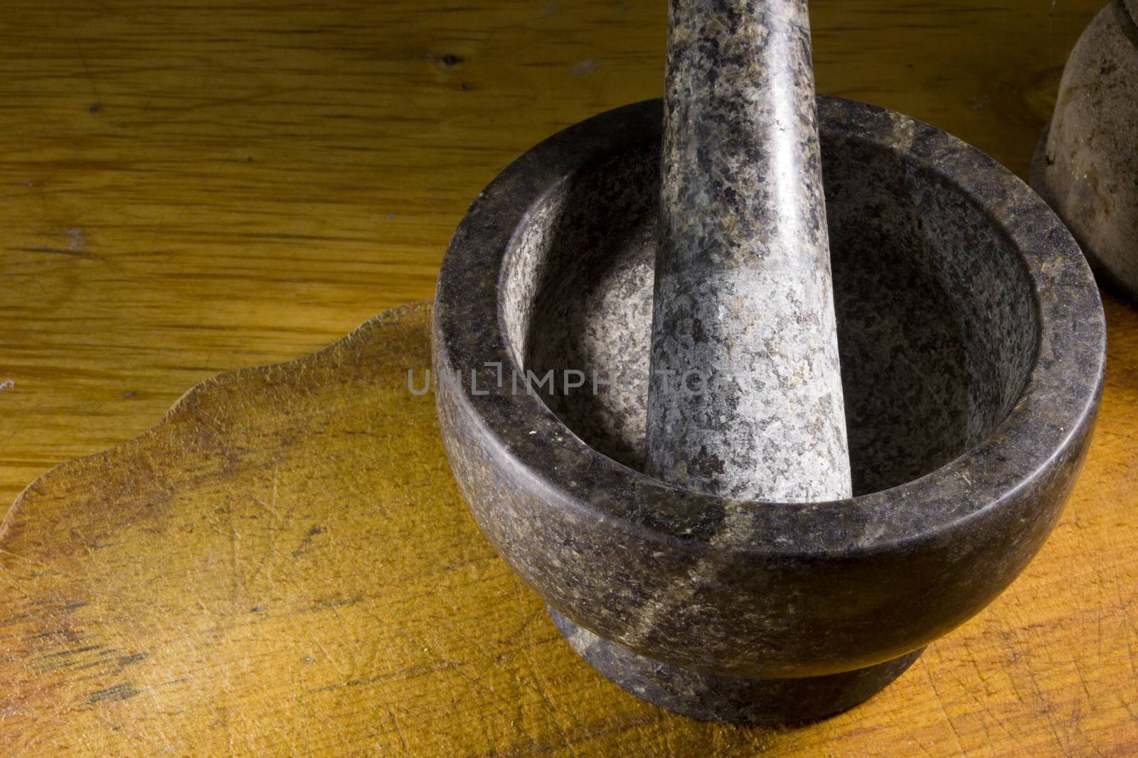 Stone mortar with a pestle on a wooden cutting board