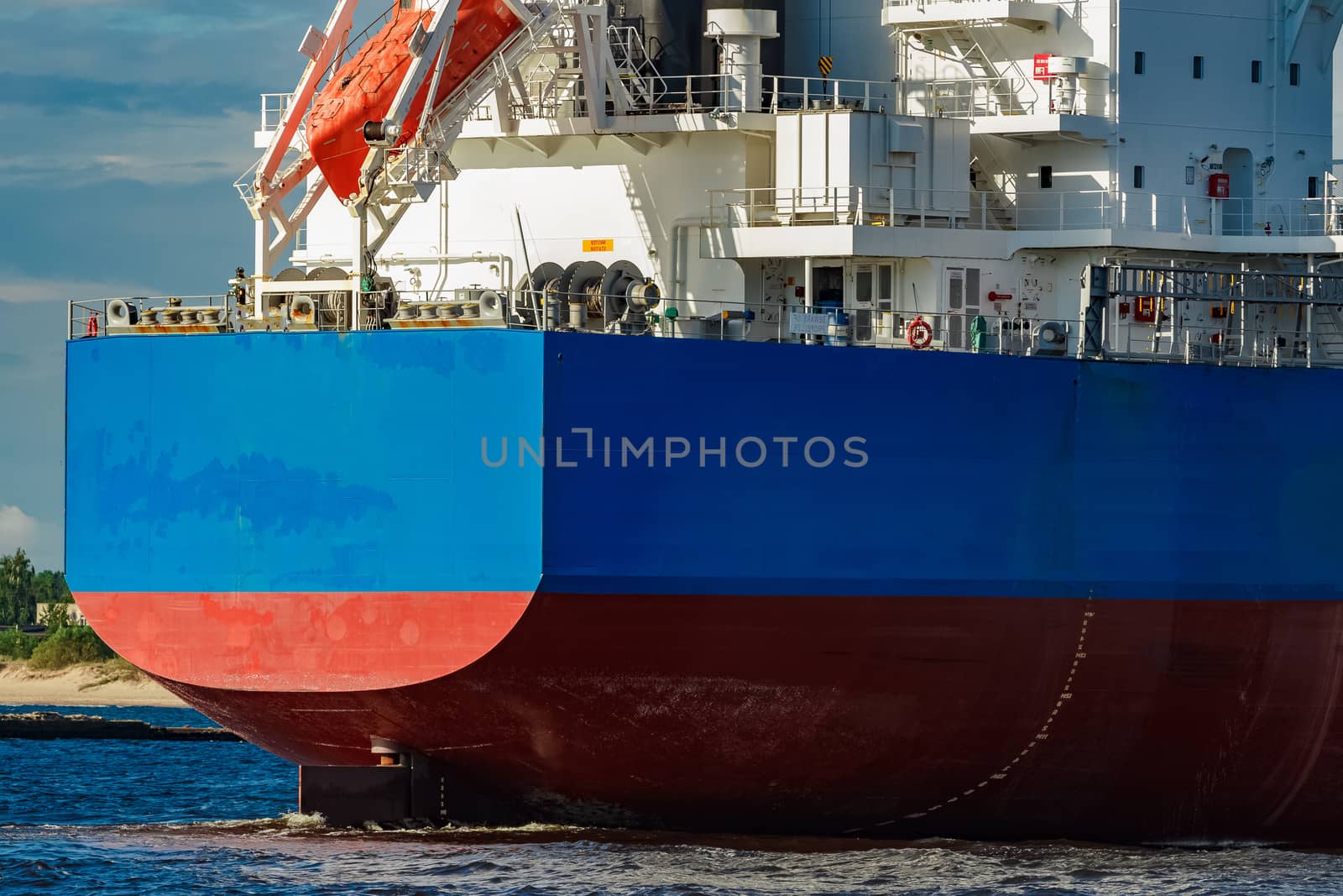 Merchandise import. Large blue cargo ship moving to Riga port