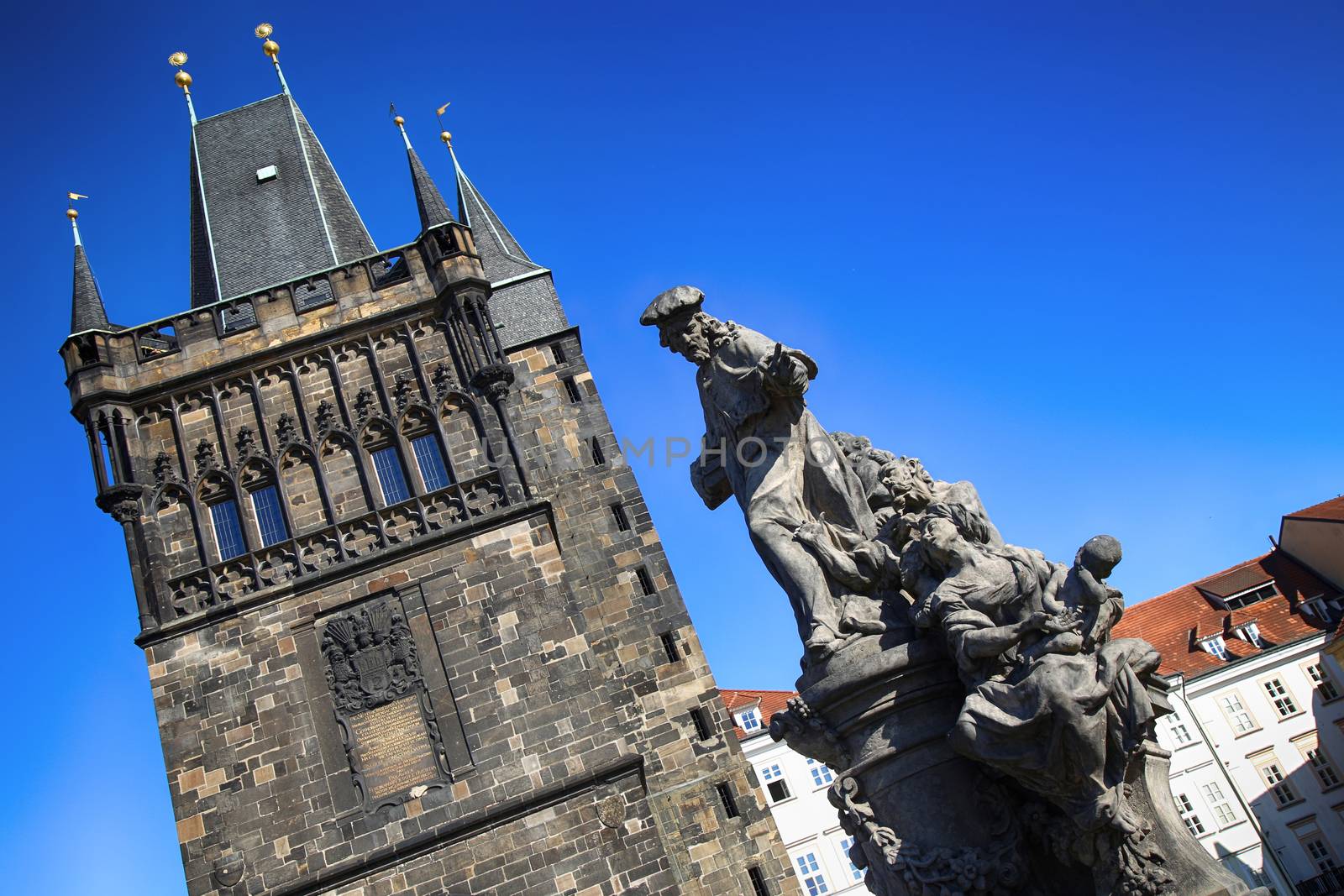 View of the Old Town Bridge Tower (Stare Mesto Tower) with statue on the Charles Bridge (Karluv Most) in Prague, Czech Republic