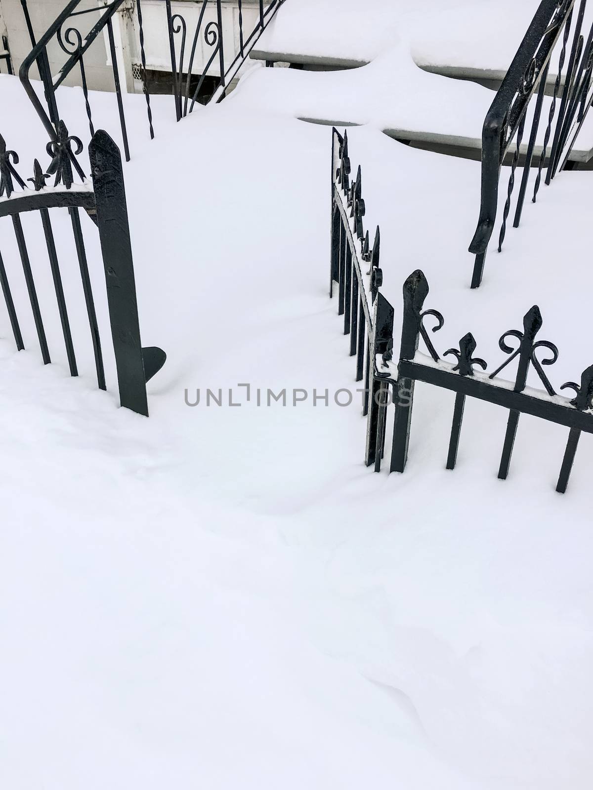 Iron fence in deep snow. Canadian winter.