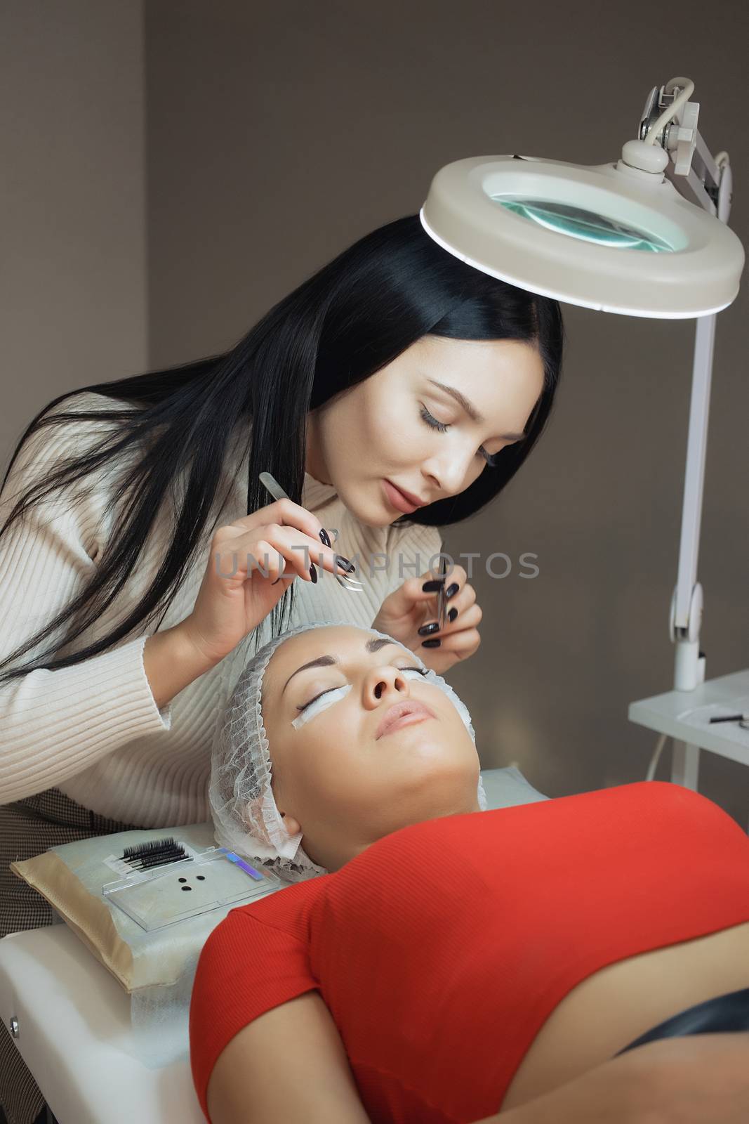 young woman working on eyelash extensions. Woman Eye with Long Eyelashes.