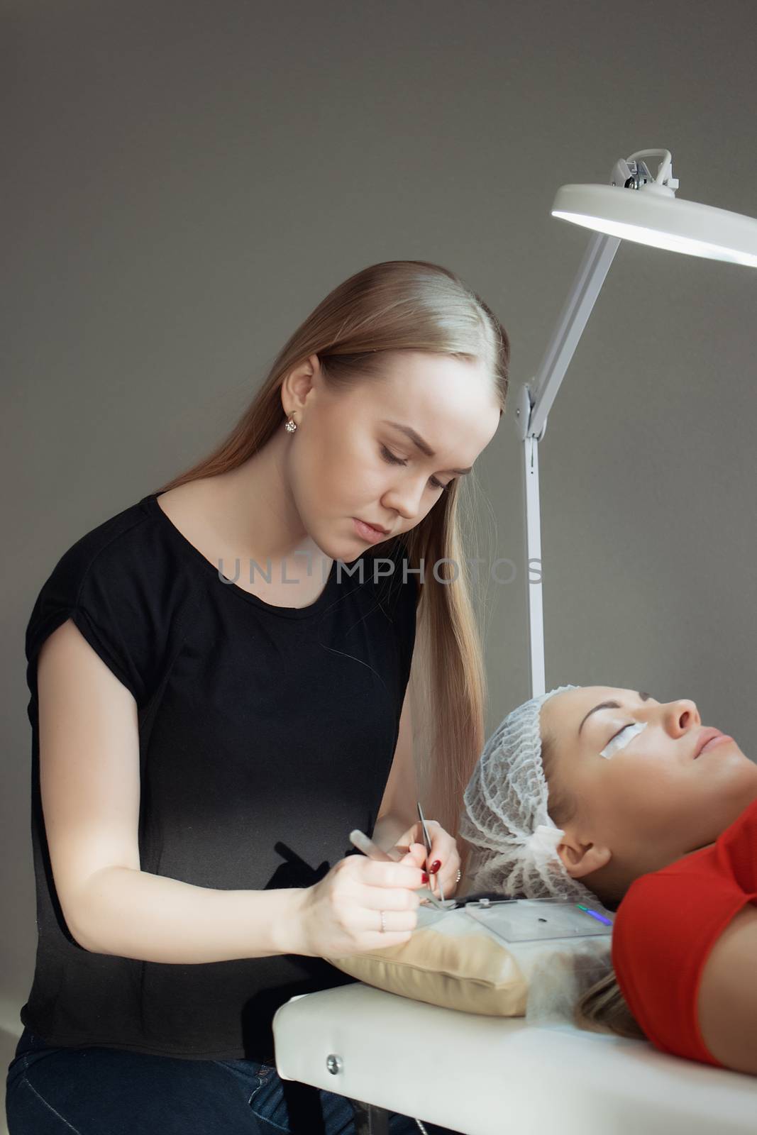 young woman working on eyelash extensions. Woman Eye with Long Eyelashes.