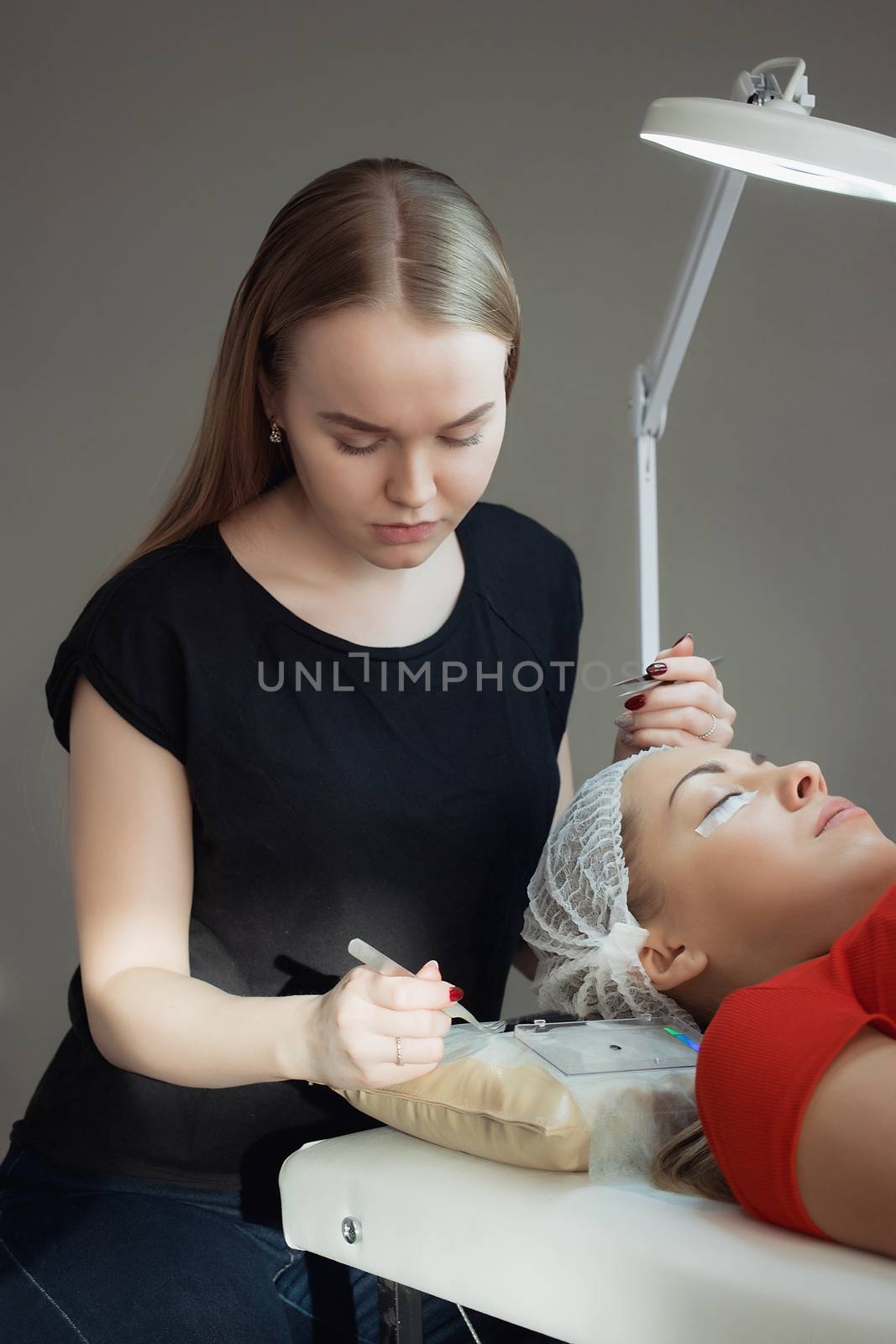 young woman working on eyelash extensions. Woman Eye with Long Eyelashes.