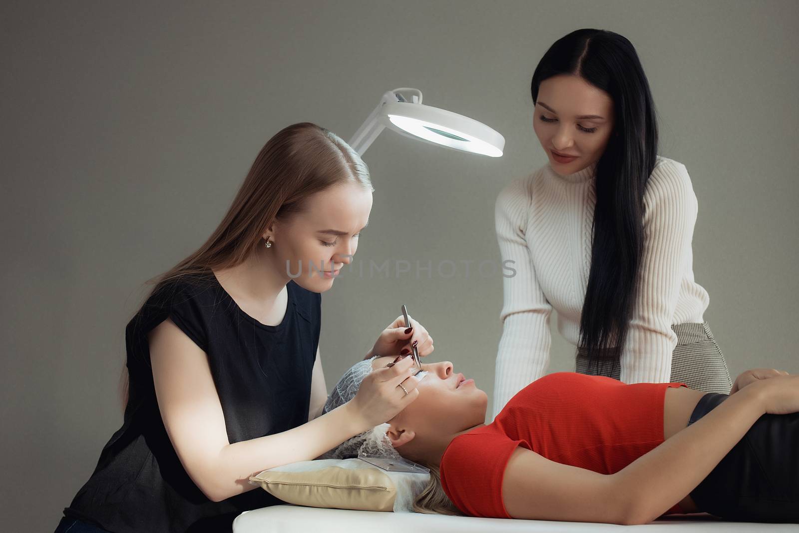 young woman working on eyelash extensions. Woman Eye with Long Eyelashes.