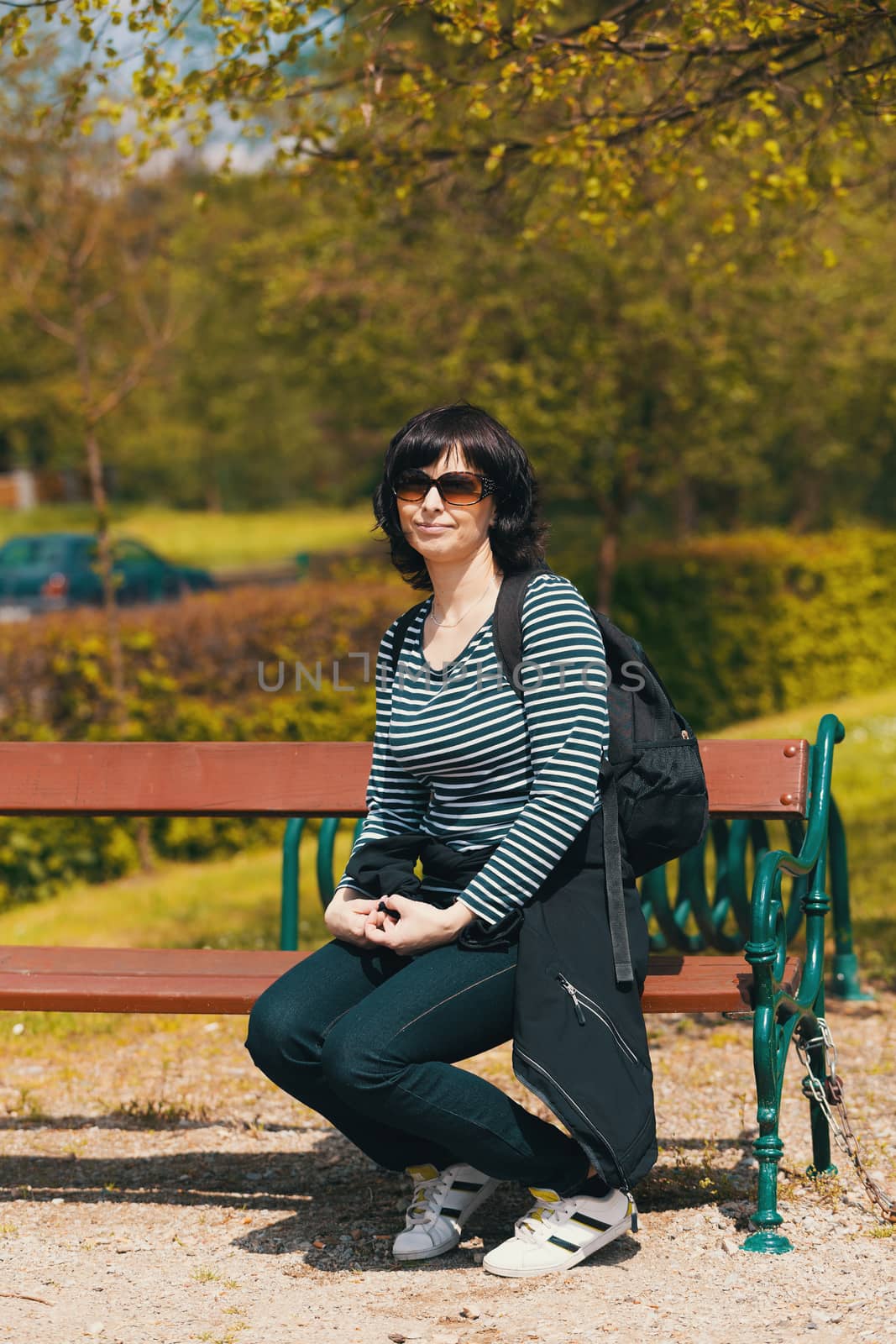 tired Middle age woman with sunglasses resting on bench