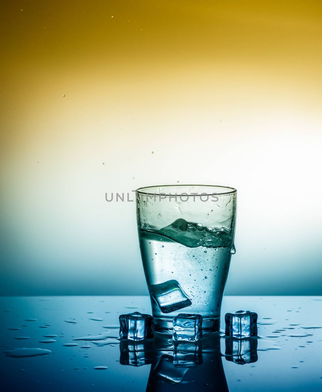 a glass of fresh clean water with falling ice cubes