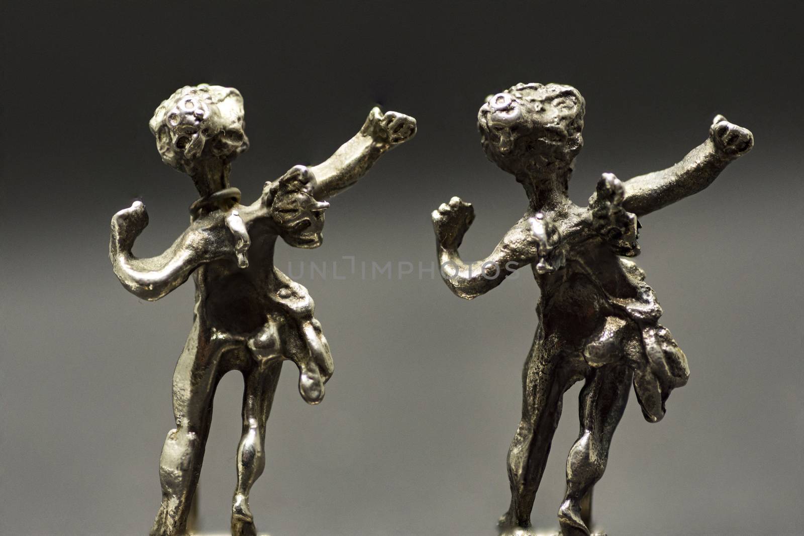two metallic figurine angels are dancing