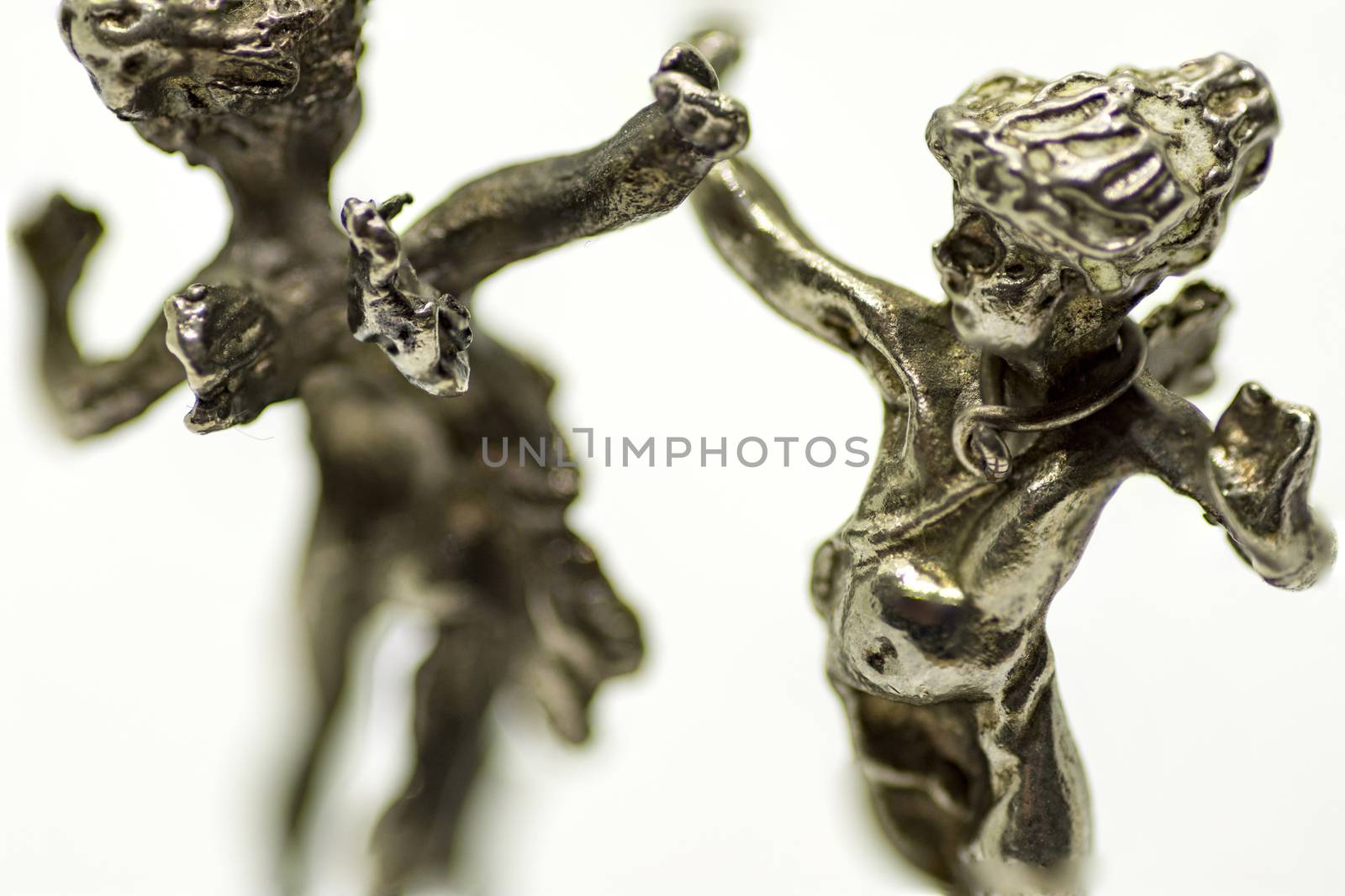 two metallic figurine angels are dancing
