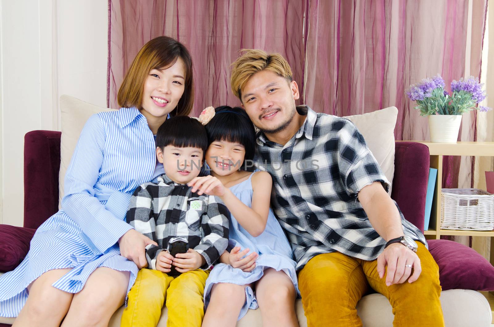 Portrait of asian family siting on the sofa at home.