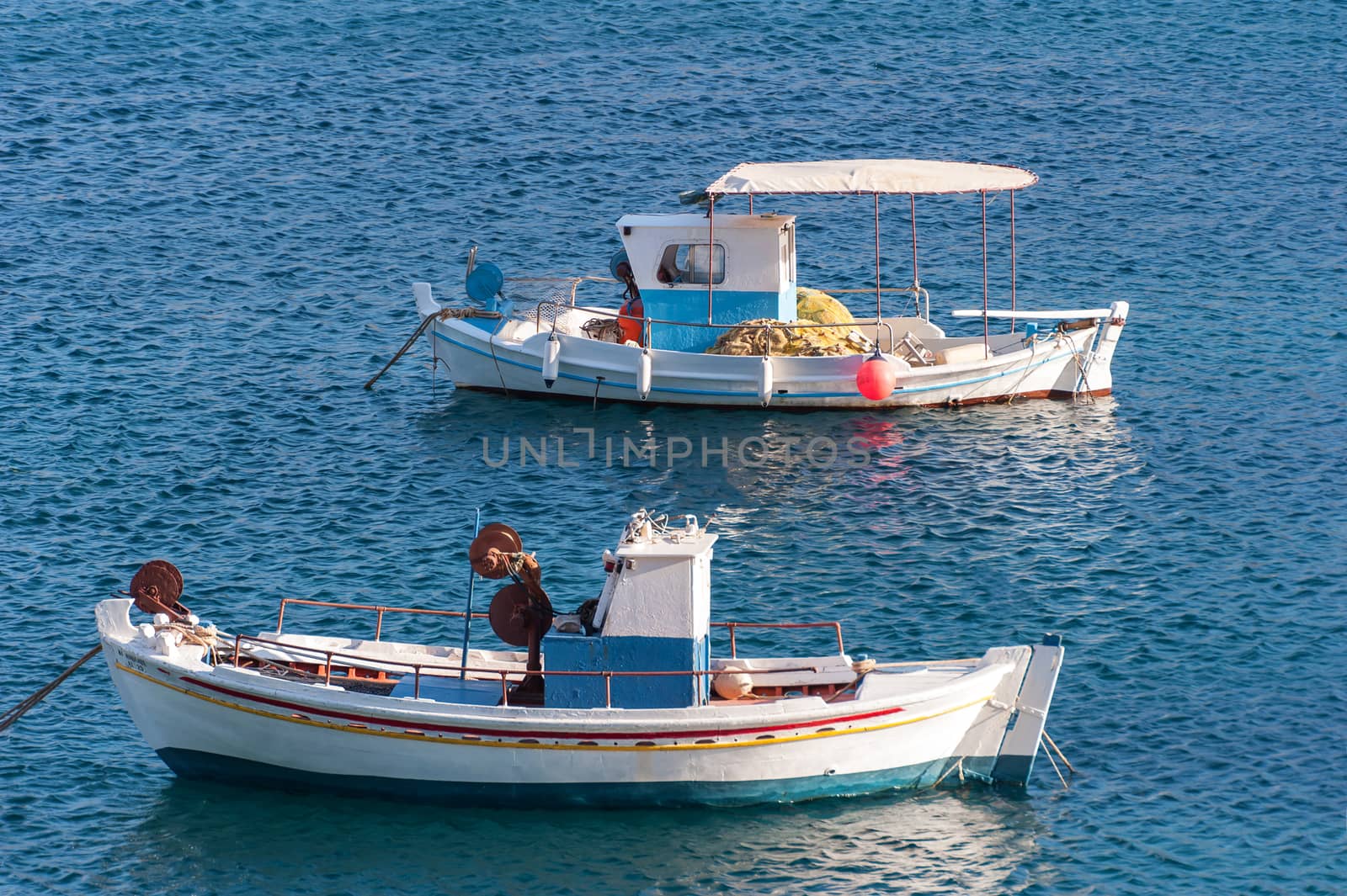 fishing boats in the blue sea of a greek island