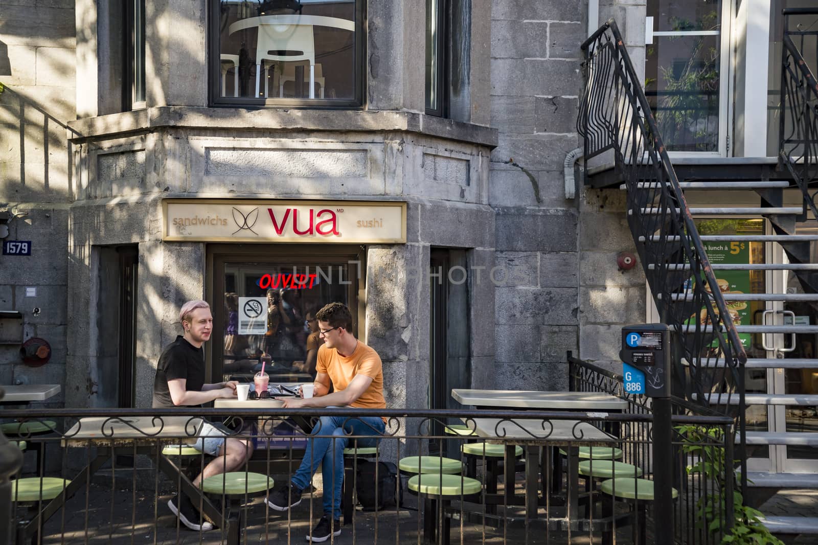 Two young men are drinking in a modern urban cafe. by edella