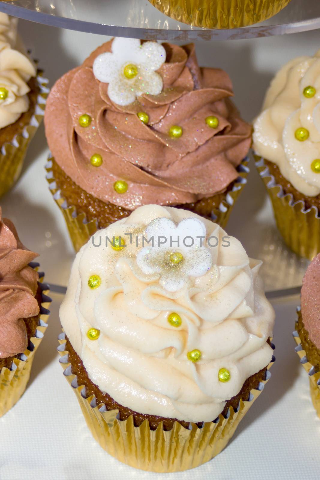 wedding cake on a table with small  cupcakes 