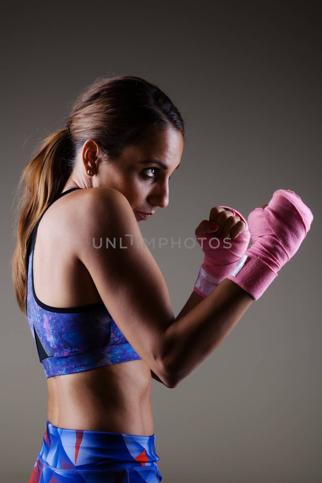 girl kickboxer posing with pink hand wraps