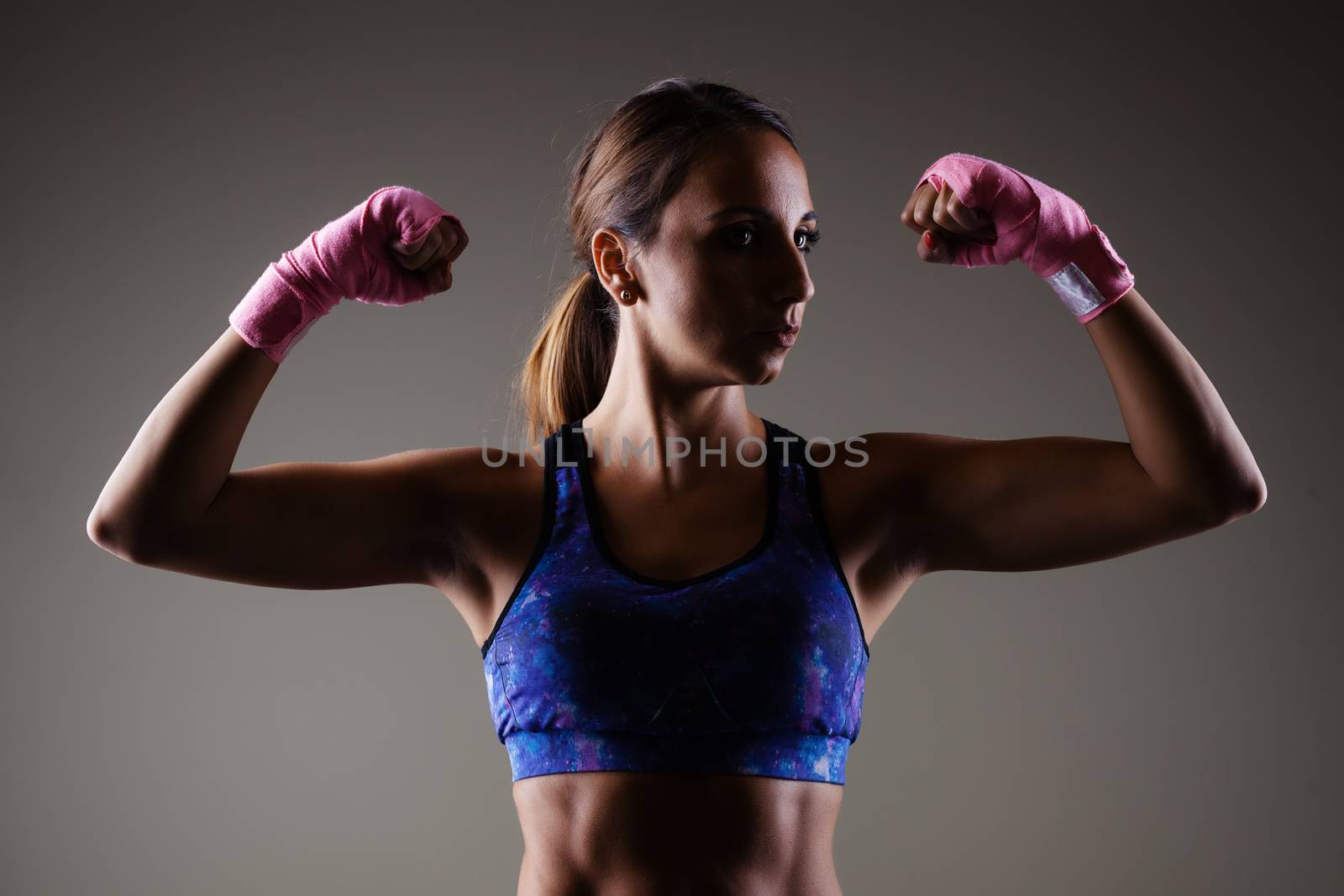 girl kickboxer posing with pink hand wraps