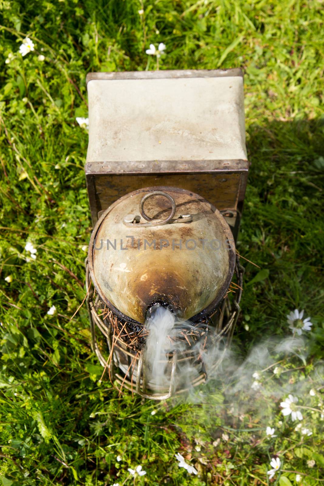 bee smoker with smoke on the ground at farm