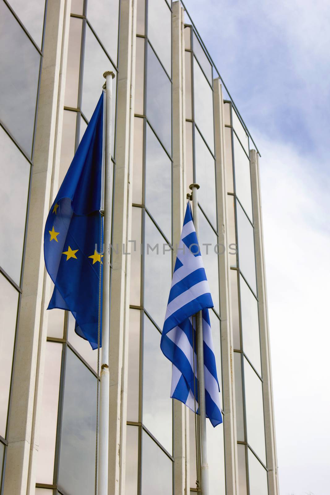 greek and european union flag outside a building in Athens