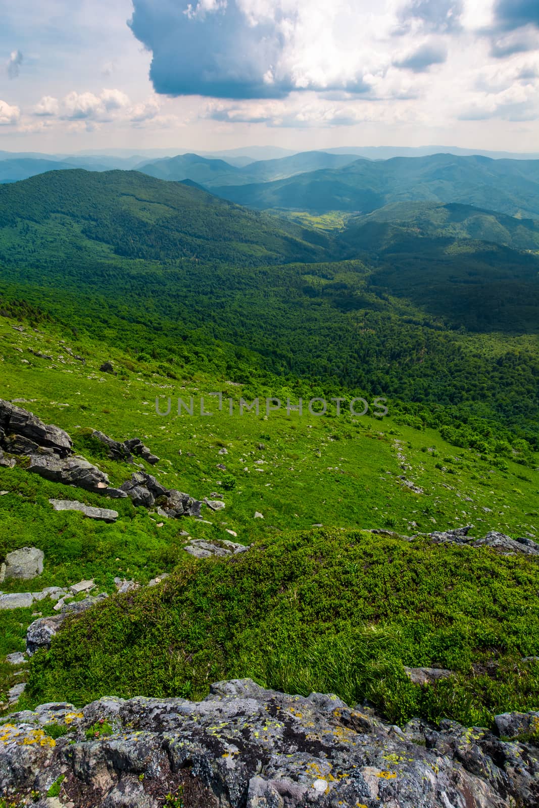 mountain behind the valley viewed from rocky cliff. beautiful summer landscape with grassy slopes under the cloudy sky. location mountain Pikui, TransCarpathia, Ukraine