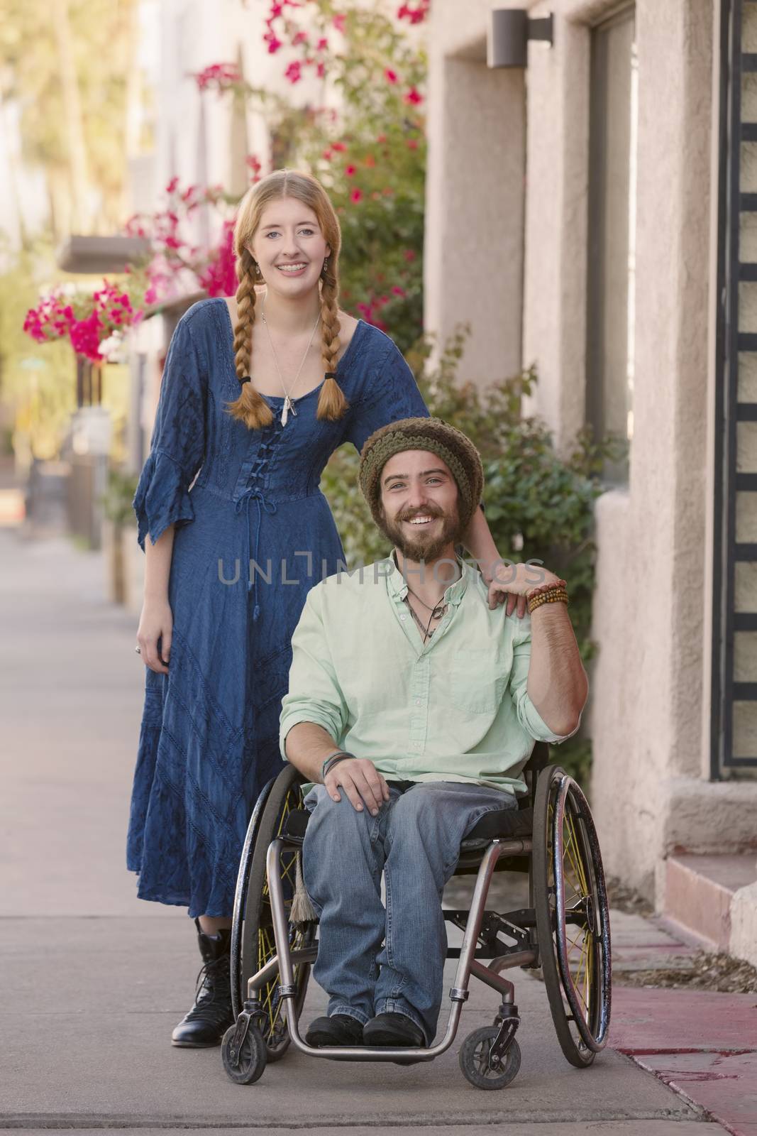 Woman with male friend in wheelchair on sidewalk