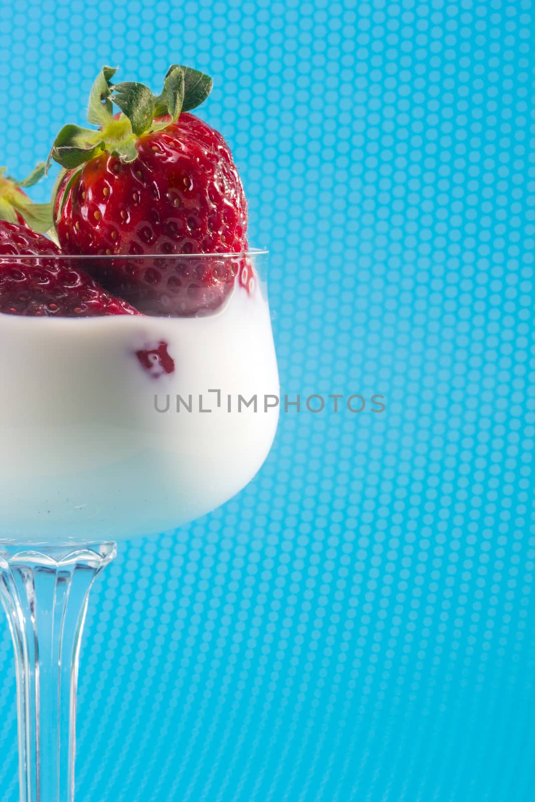 fresh strawberries on a glass filled with cream 