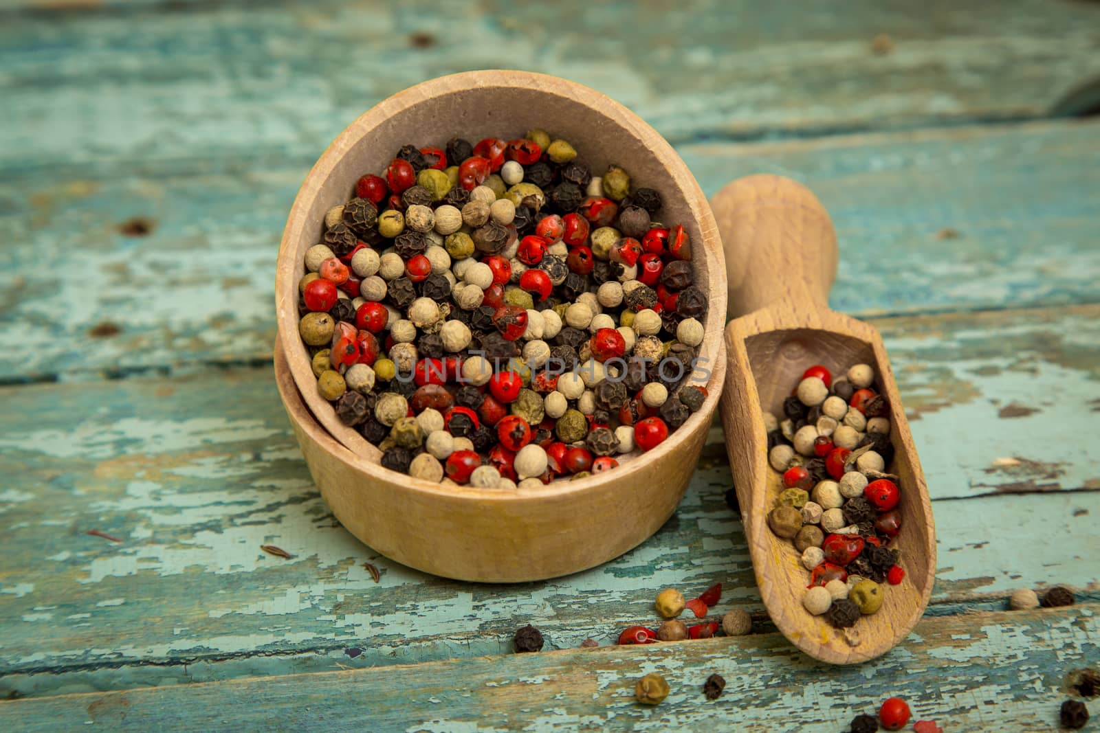 Mixed peppercorns in a wooden bowl.