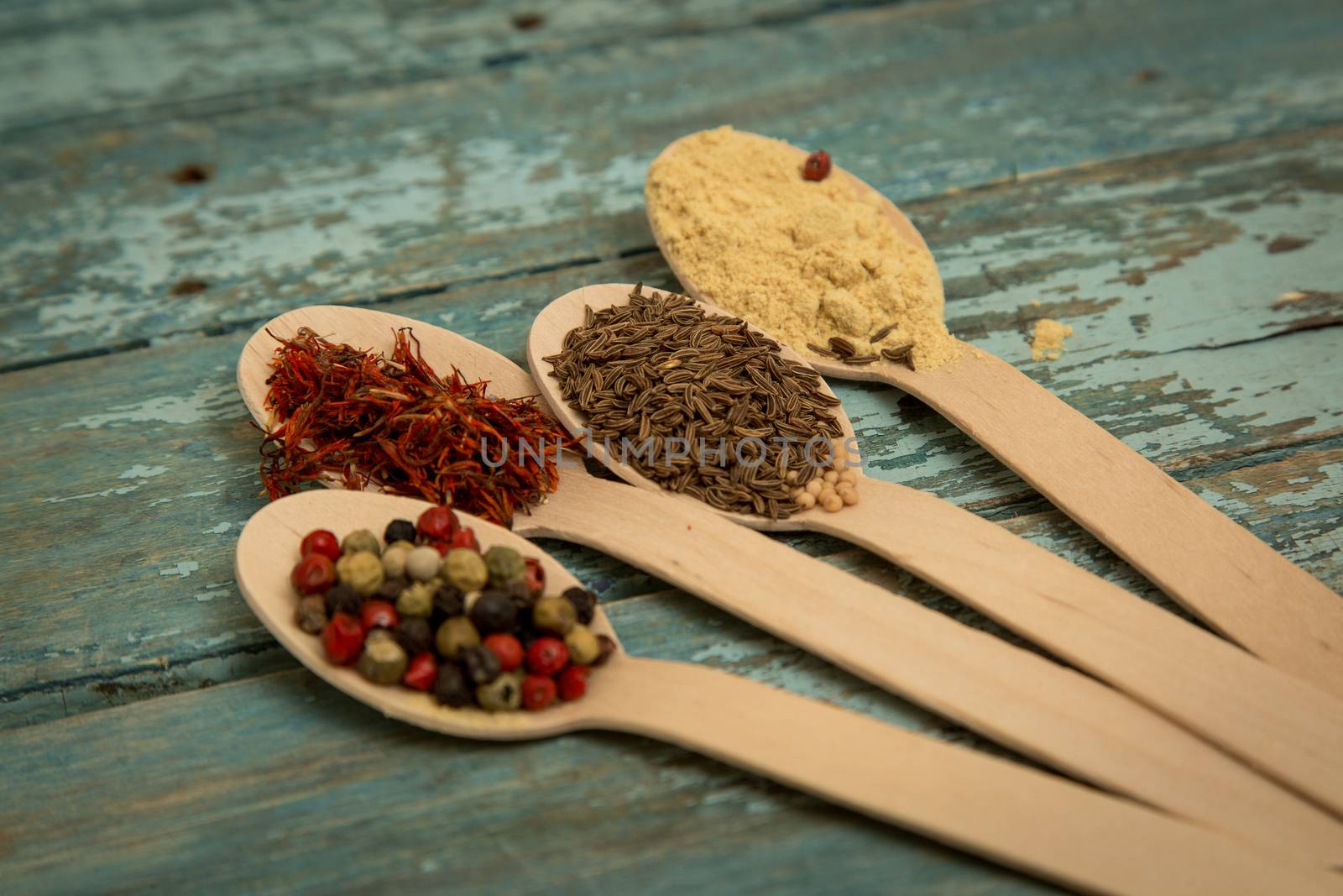 Saffron, pepper, cumin and mustard in a wooden spoons