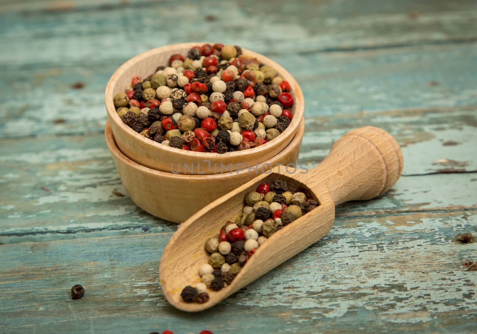Mixed peppercorns in a wooden bowl.