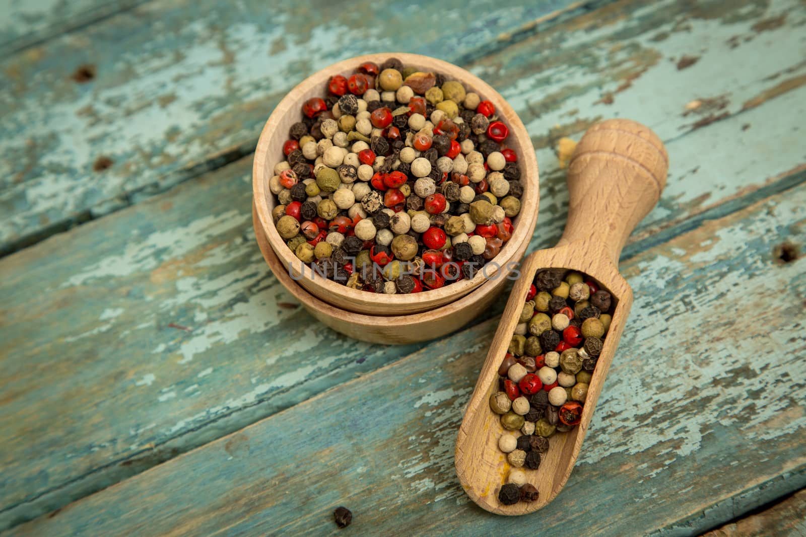 Mixed peppercorns in a wooden bowl.