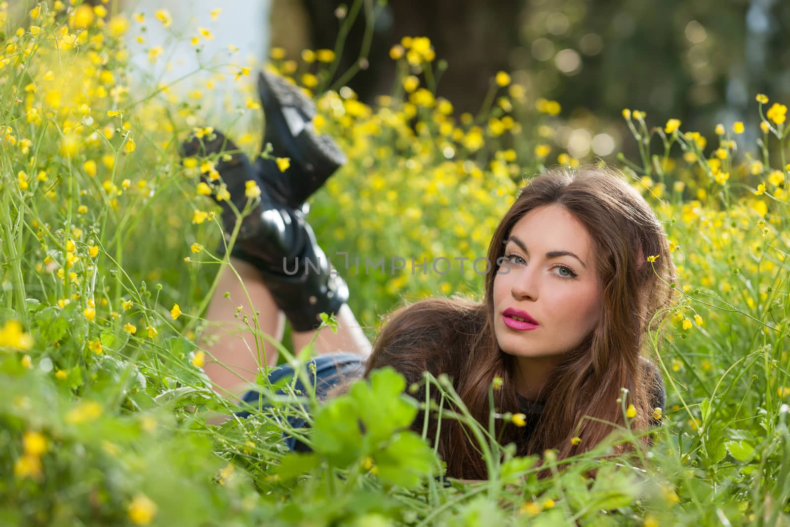 portrait of a beautiful young girl among yellow flowers in the nature