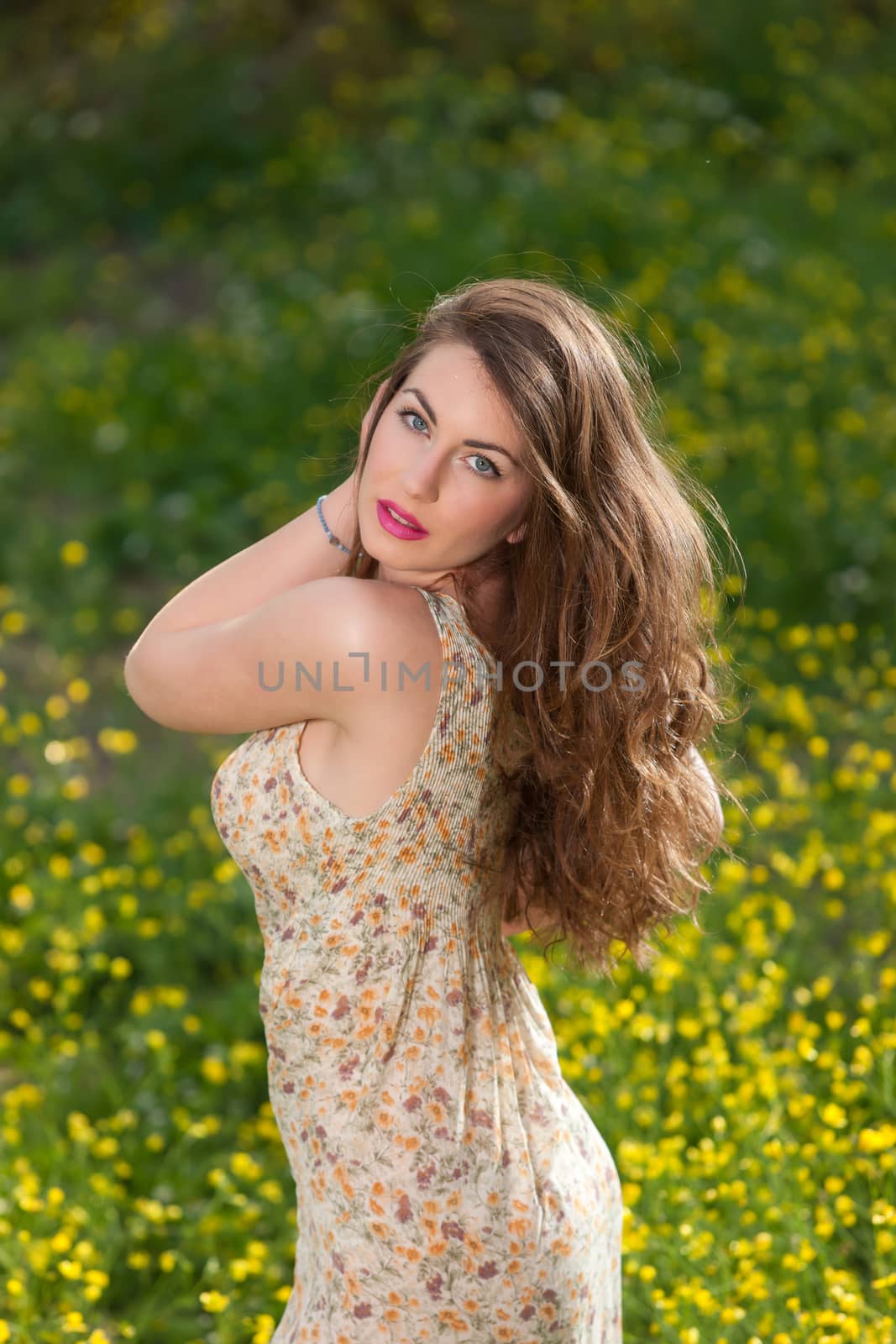 portrait of a beautiful young girl among yellow flowers in the nature