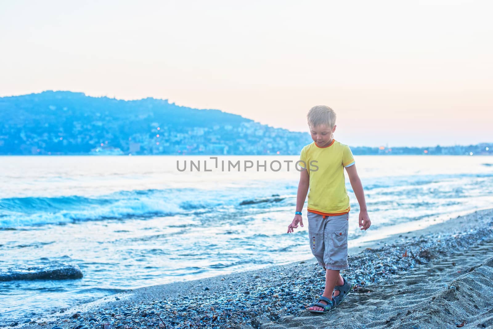 Kid boy walking at Alania beach, Turkey