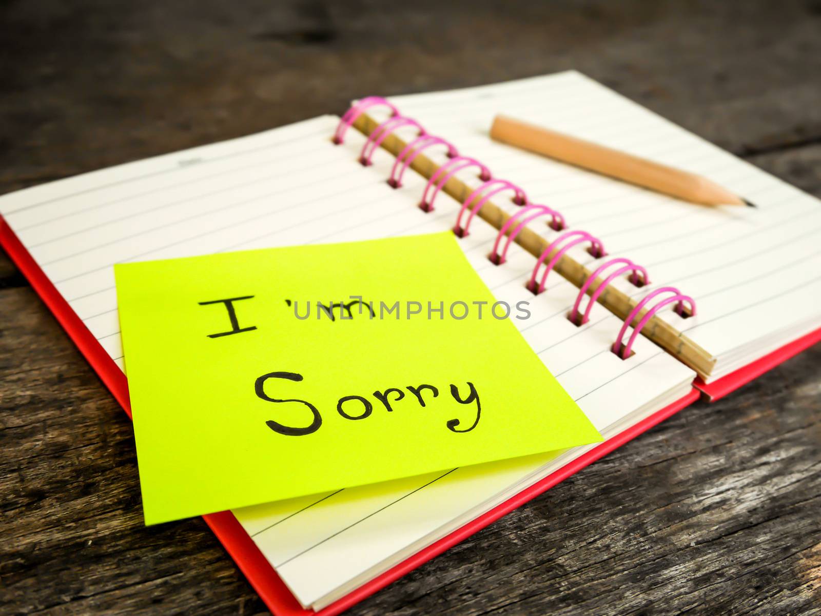 Sorry paper note in note book on wooden table with selective focus