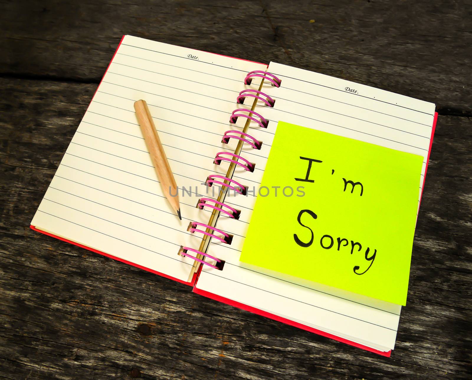 Sorry paper note in note book on wooden table