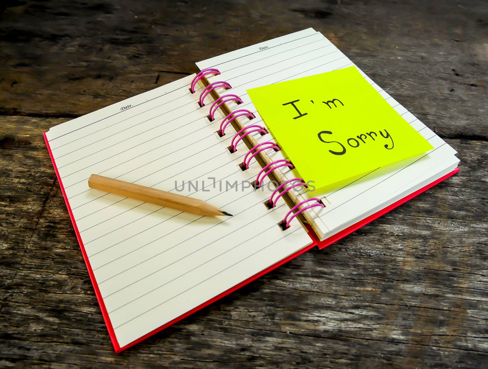 Sorry paper note in note book on wooden table