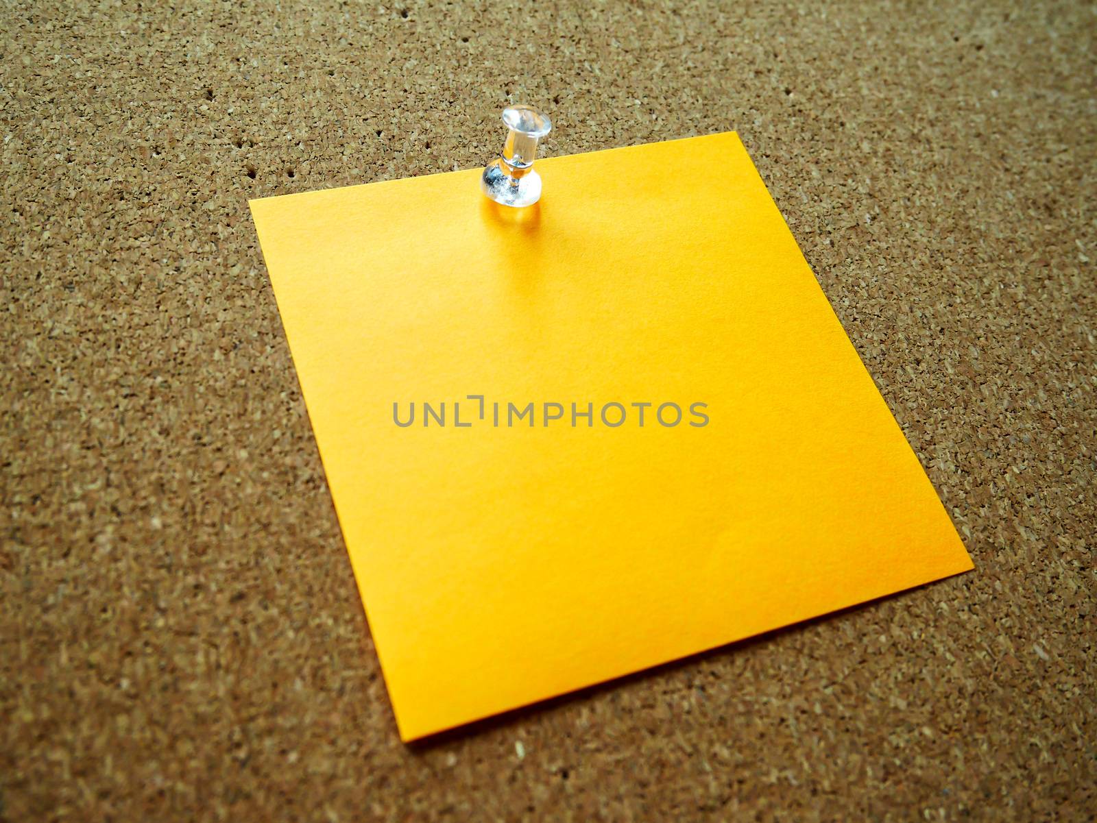 Orange post it note on wooden board 