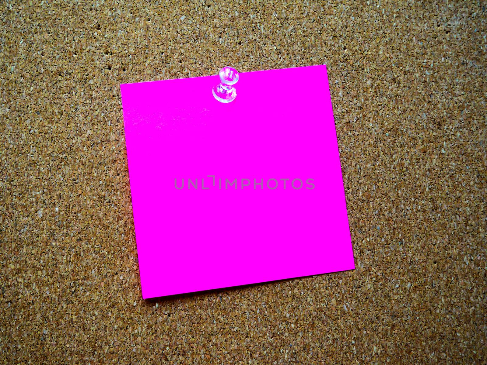 Pink post it note on wooden board