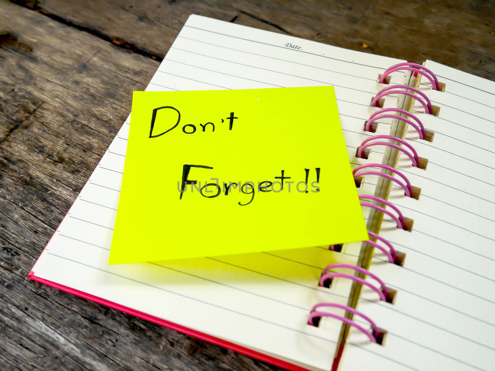 Focus reminder paper note in note book on wooden table 