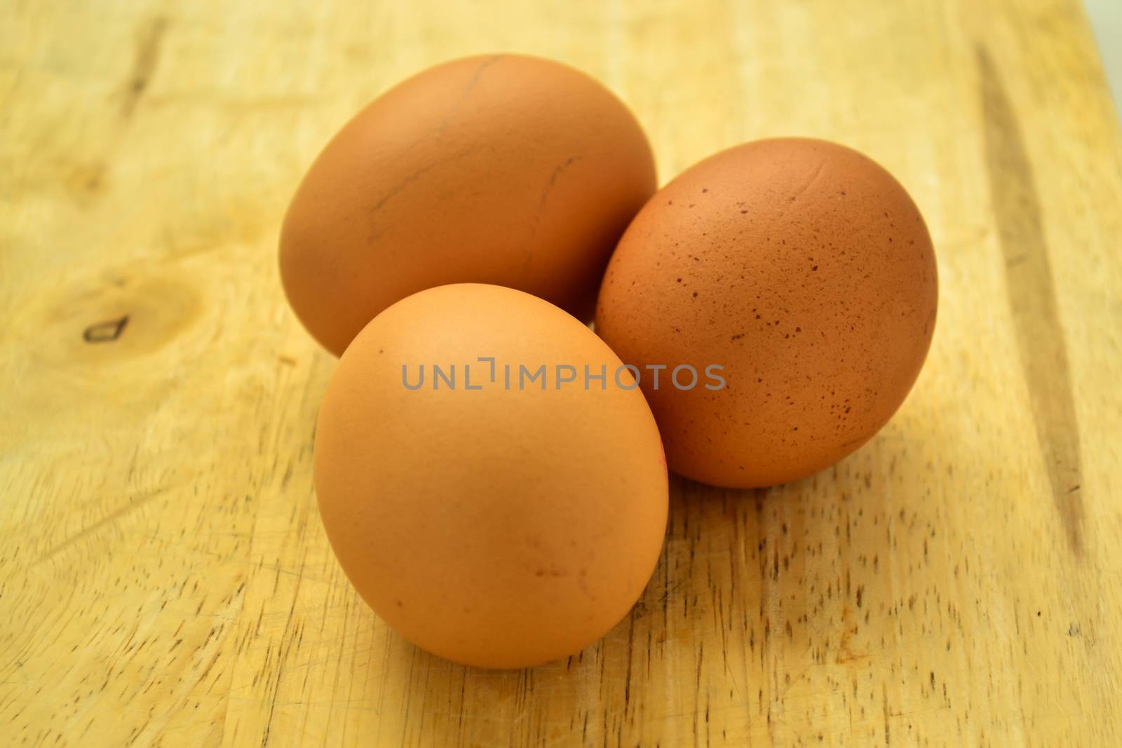 Selective focus three eggs on wooden board