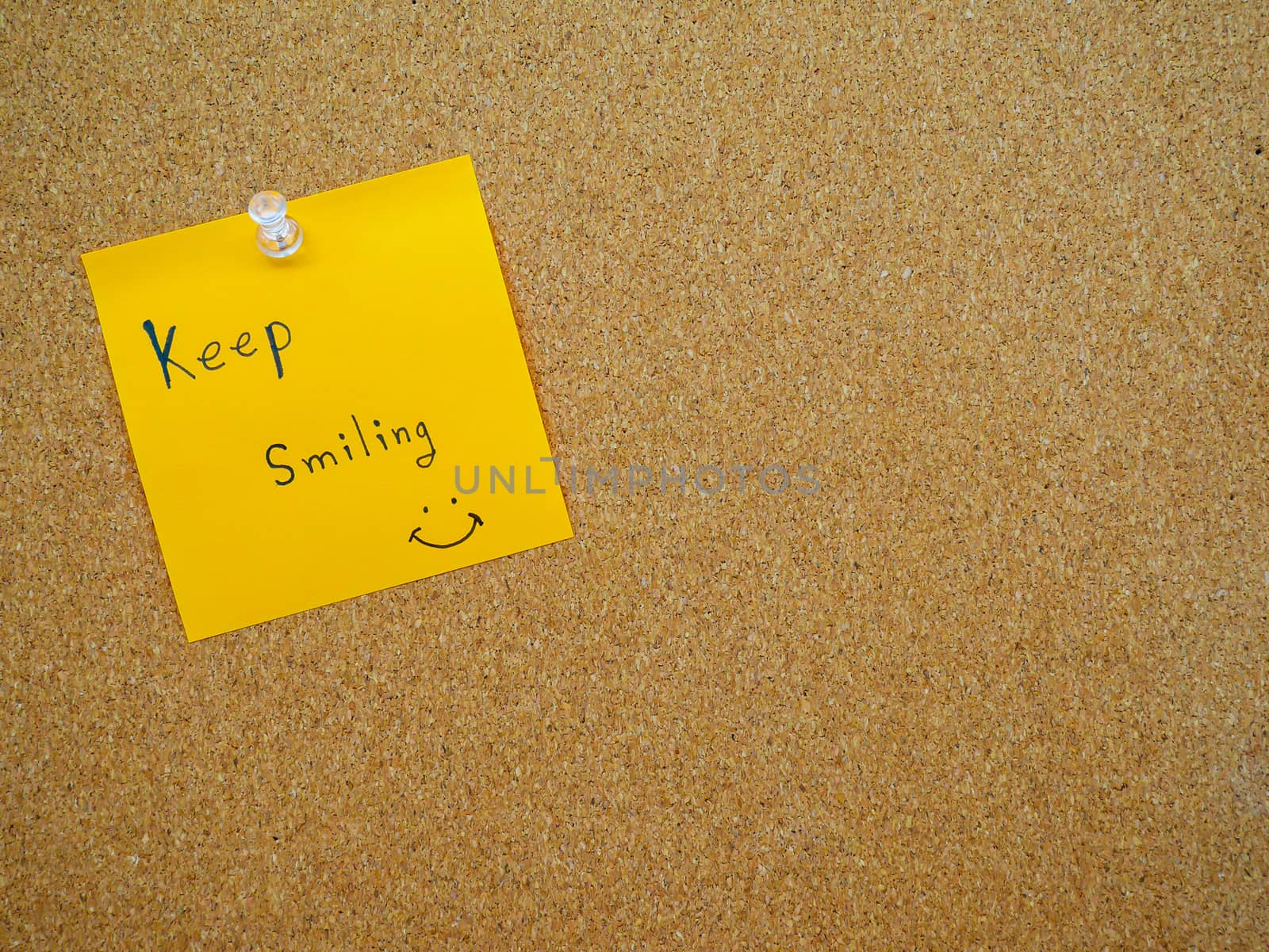 Keep smiling in post note on wooden board with copy space
