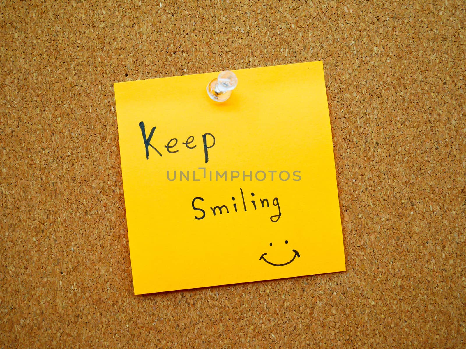 Keep smiling in post note on wooden board 